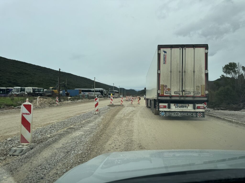 Road construction on Montenegro coastal highway — gravel detour with truck and traffic cones