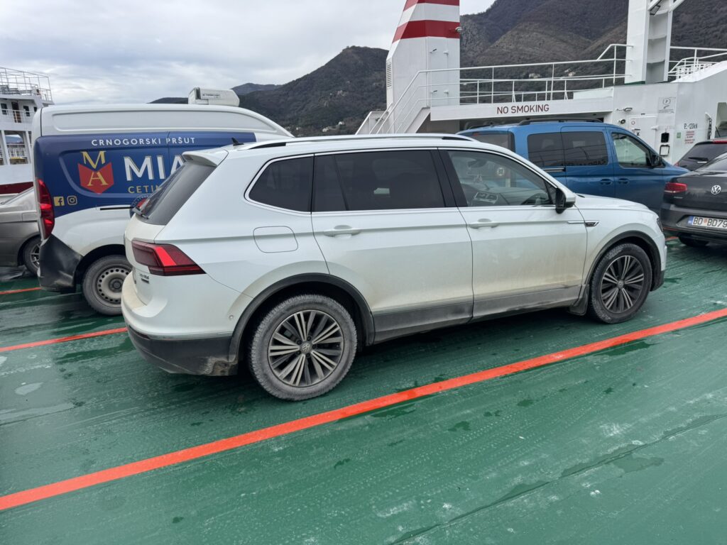 Car on Bay of Kotor ferry deck — Budva to Dubrovnik road trip winter crossing