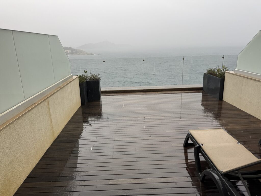 Rain on Rixos Premium Dubrovnik hotel terrace — wet deck and grey Adriatic sea view