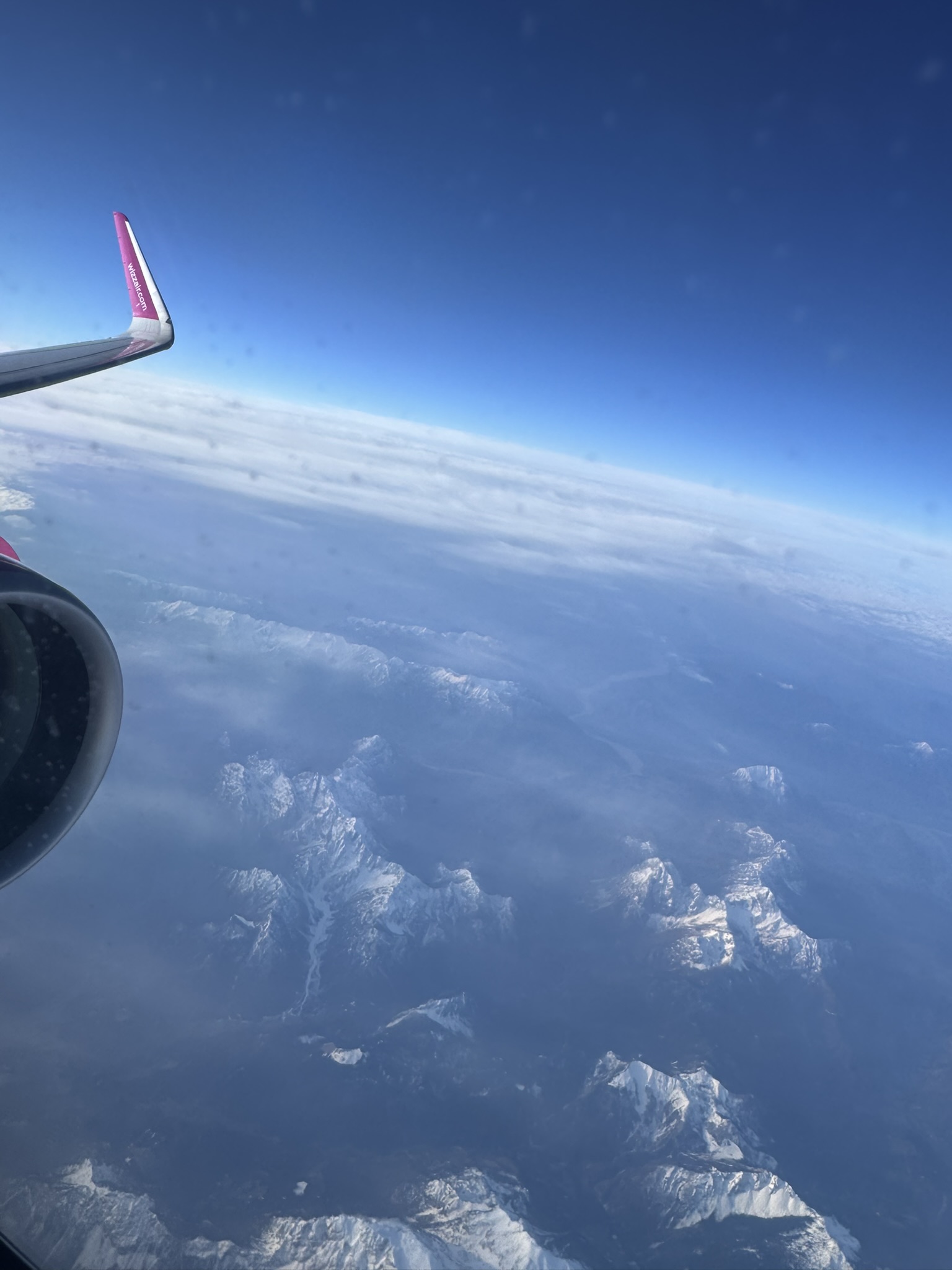 Airplane wing above clouds on the TIA to Beauvais flight for a France road trip