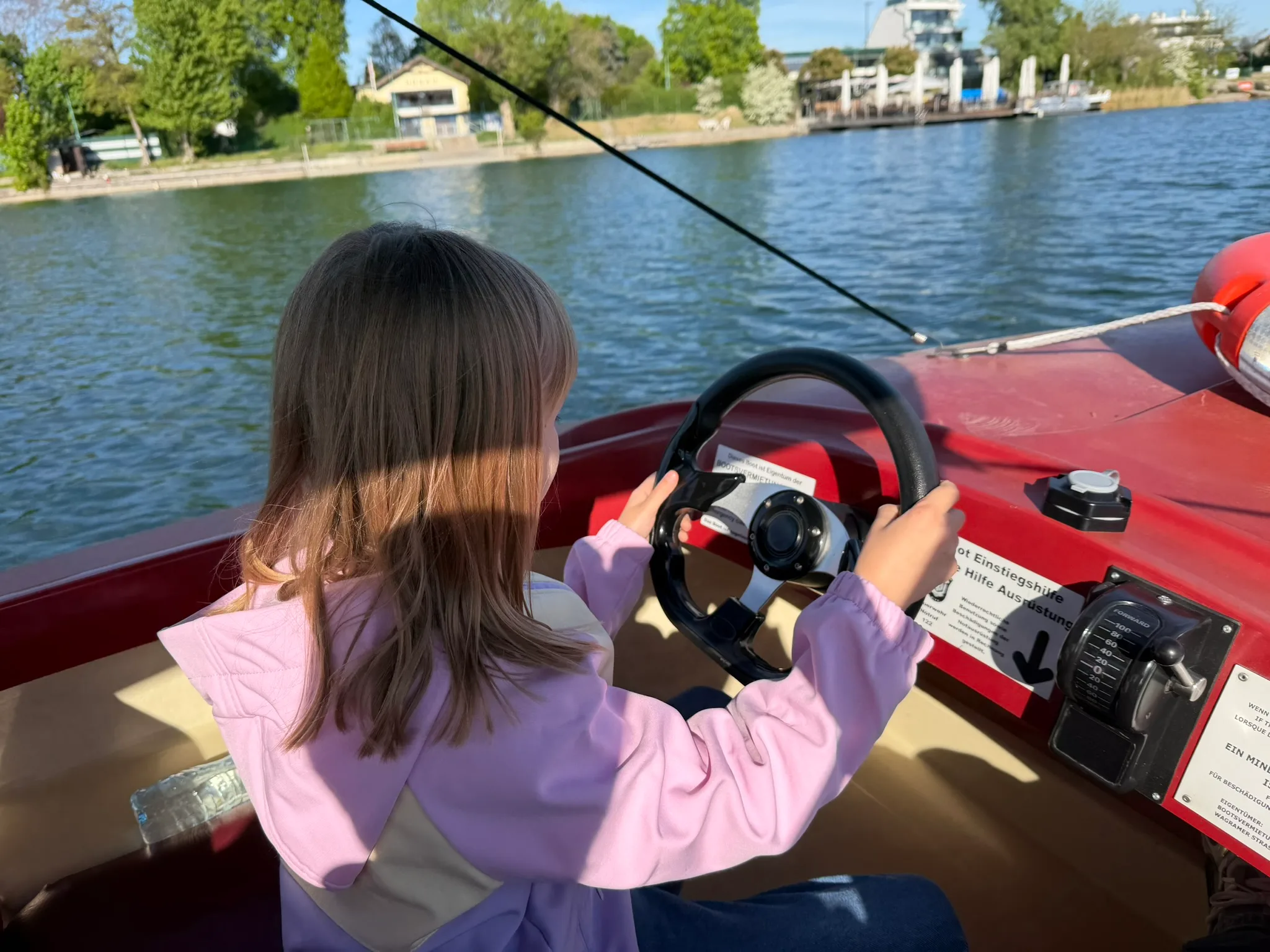 Child steering an electric boat on Alte Donau in Vienna.